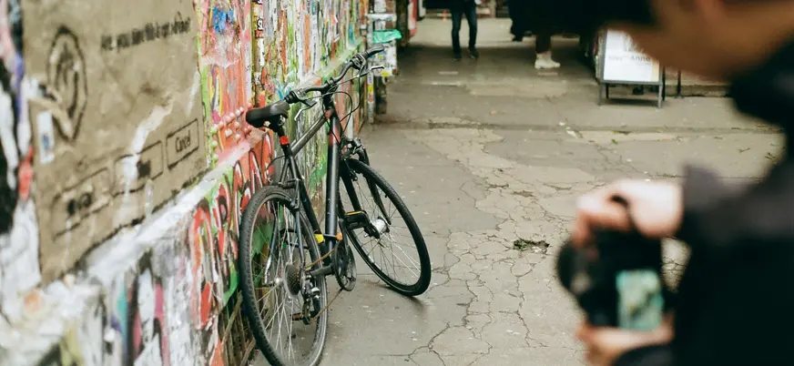 Bicicleta apoyada en un callejón lleno de grafitis en Berlín