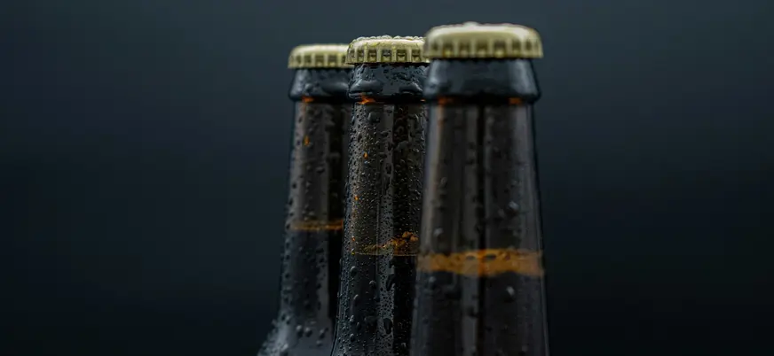 Primer plano de botellas de cerveza artesanal sobre fondo oscuro