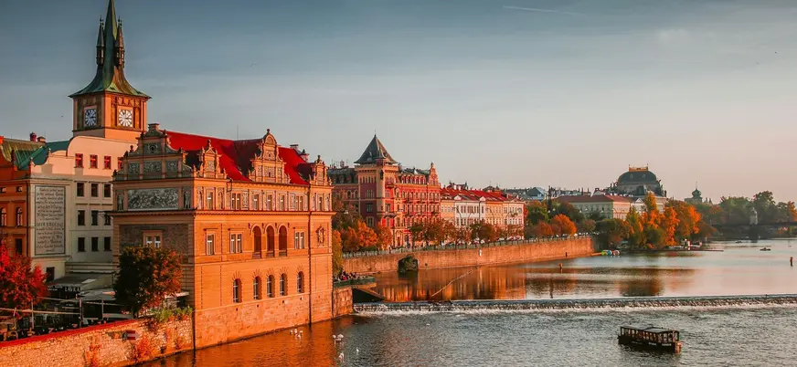Edificios históricos a orillas del río Moldava al atardecer en Praga.