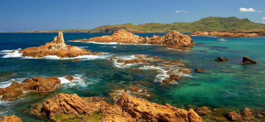 Islotes rojizos y aguas cristalinas en la costa norte de Menorca