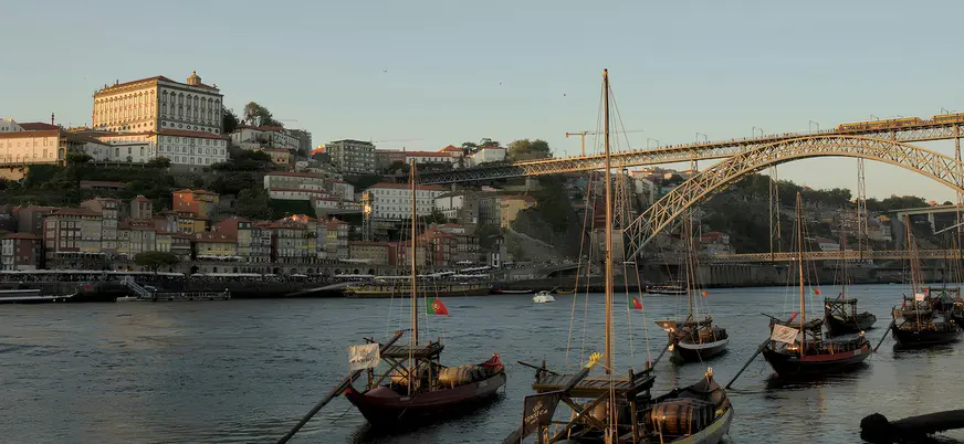 Barcos rabelos frente al puente de Don Luis I al atardecer en Oporto.