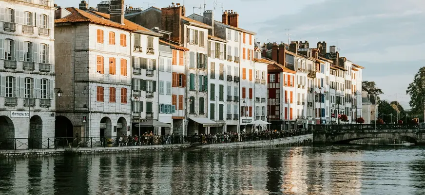 Fachadas con contraventanas de colores junto al río en Bayona.