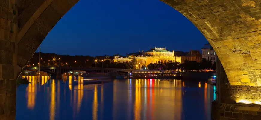 Vista nocturna del Rudolfinum desde un arco del puente en Praga, República Checa