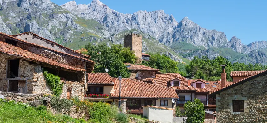 Casas rurales y torre medieval de Mogrovejo ante los Picos de Europa