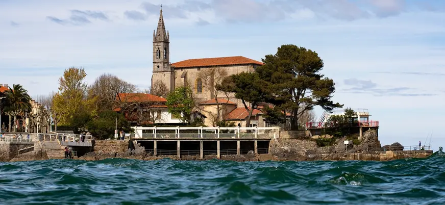 Iglesia de Santa María junto al mar y el paseo marítimo en Mundaka, Vizcaya