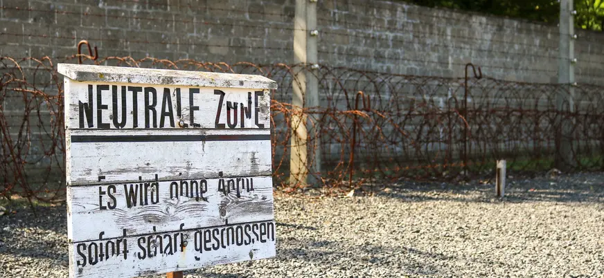 Cartel de madera que advierte "Neutrale Zone" frente a las vallas de espino en Sachsenhausen