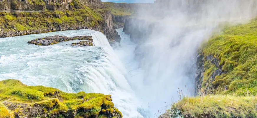 Catarata Gullfoss en Islandia, una de las más impresionantes del Círculo Dorado, rodeada de verdes acantilados.