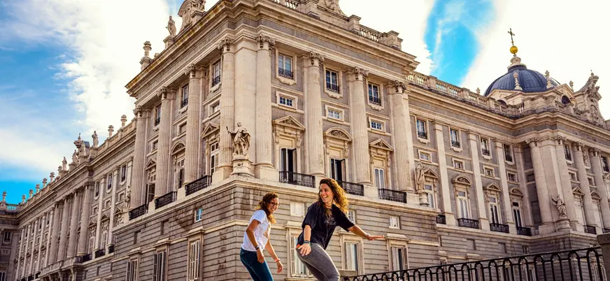 Dos jóvenes montando en monopatín frente al Palacio Real de Madrid