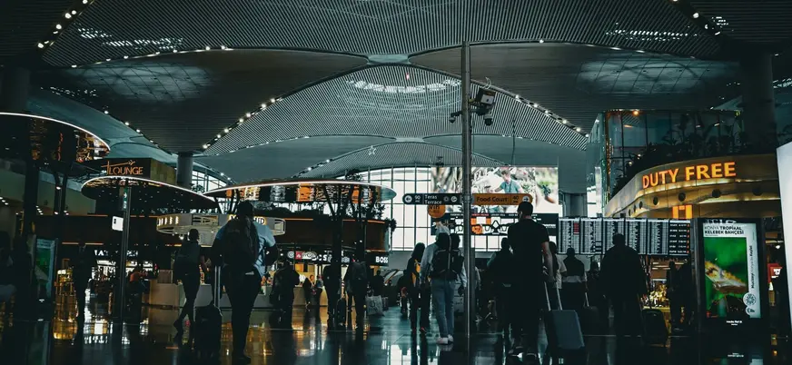 Interior del aeropuerto de Estambul con viajeros y zona duty free, Turquía