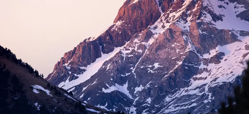 Primer plano de una montaña nevada al amanecer en Aínsa, Huesca.