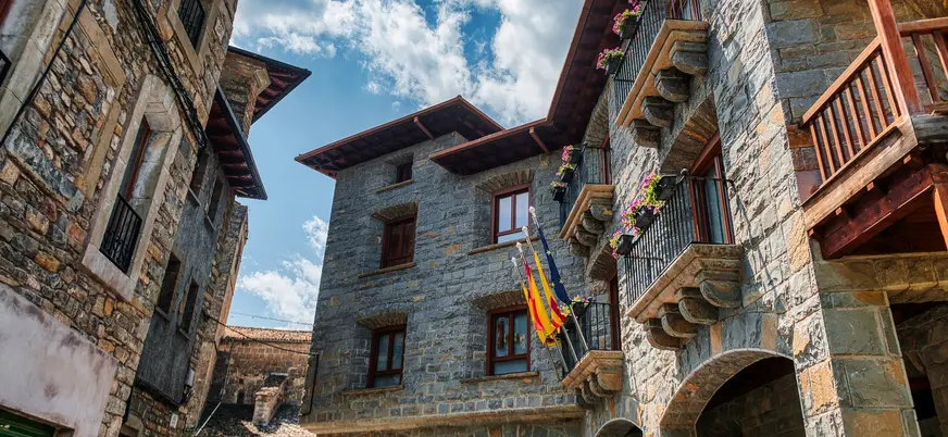 Arquitectura tradicional de piedra con balcones en la plaza de Aínsa, Huesca.