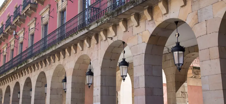 Detalle de los arcos porticados y balcones de la Plaza Mayor de Gijón, uno de los lugares más emblemáticos del centro histórico