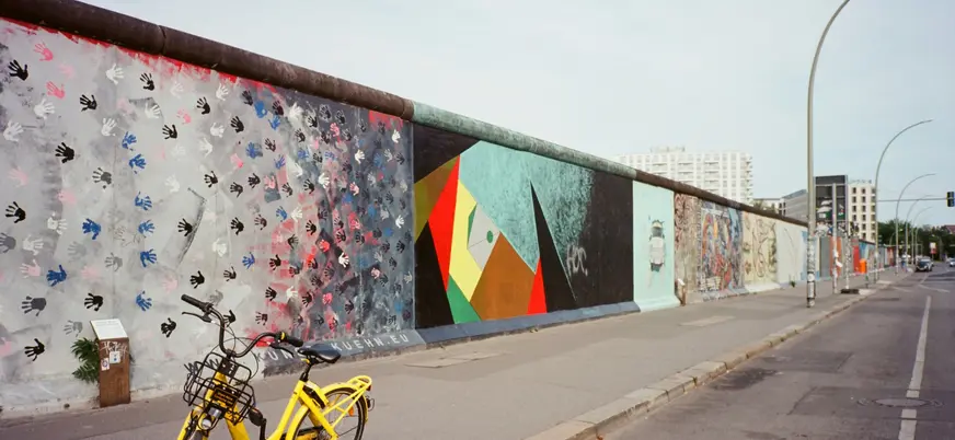 Murales de la East Side Gallery del Muro de Berlín con una bicicleta amarilla en primer plano