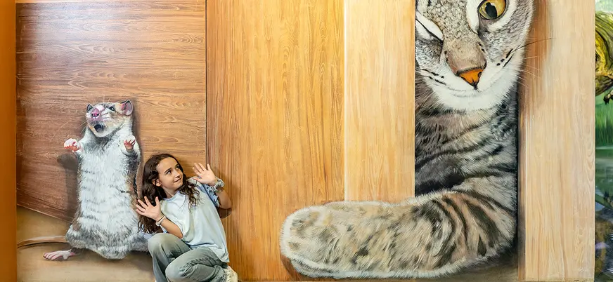 Niña posando con mural 3D de gato y ratón en el Museo de Ilusiones de Barcelona