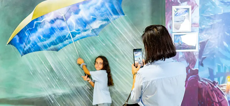 Niña posando con paraguas en pintura 3D en Museum of Illusions Barcelona