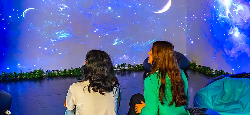 Visitantes ante proyección inmersiva del espacio en Big Fun Museum Barcelona