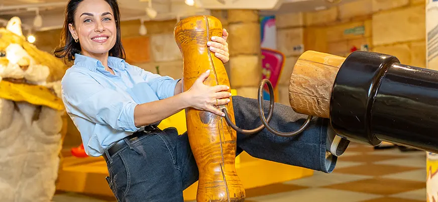 Mujer posando con objetos gigantes de madera en Big Fun Museum Barcelona
