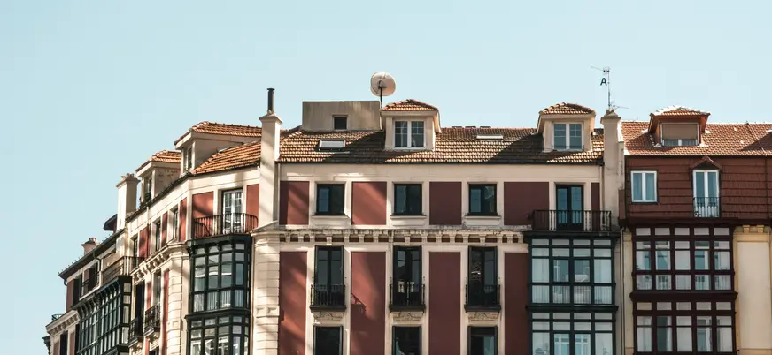 Fachadas tradicionales con balcones en el Casco Viejo de Bilbao bajo cielo despejado.
