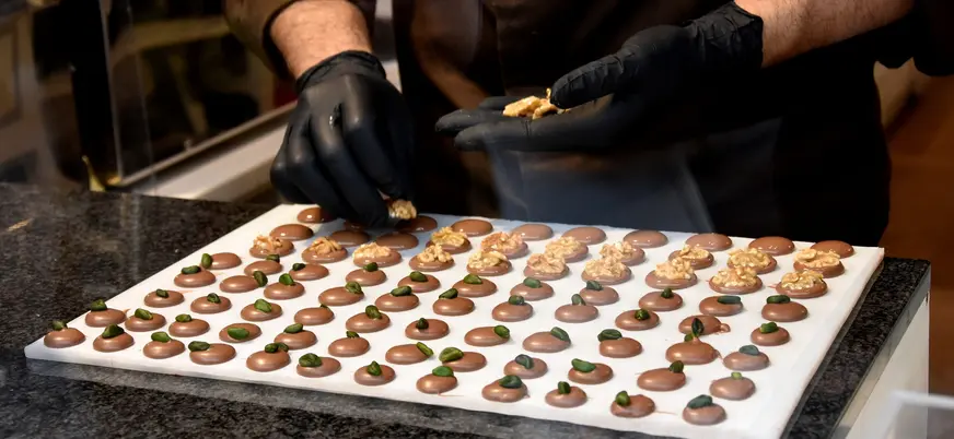 Persona colocando nueces sobre bombones de chocolate, Brujas
