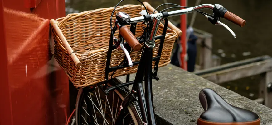 Bicicleta clásica aparcada junto a un canal en Brujas