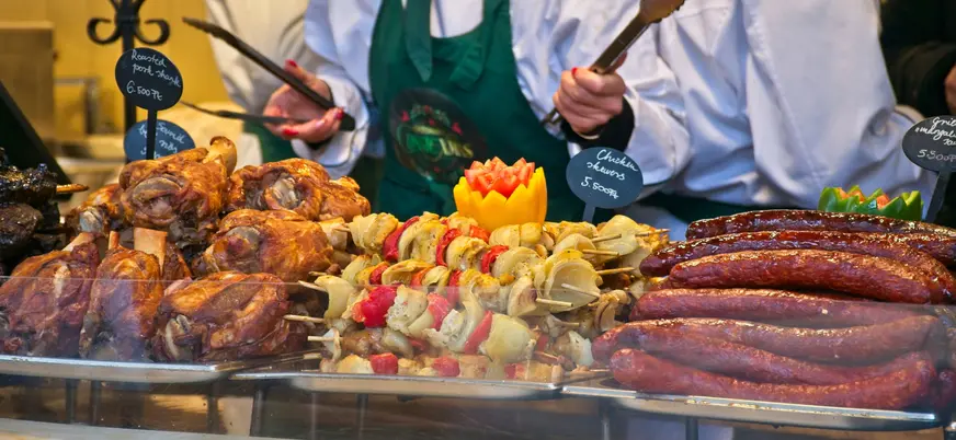 Salchichas y carne asada en un puesto de comida del Mercado de Navidad de Budapest.