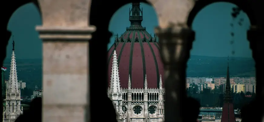 Cúpula del Parlamento enmarcada desde los arcos del Bastión de los Pescadores en Budapest
