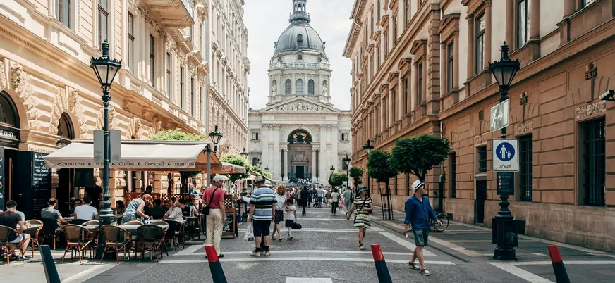 Calle concurrida del centro de Budapest con vista a la Basílica de San Esteban