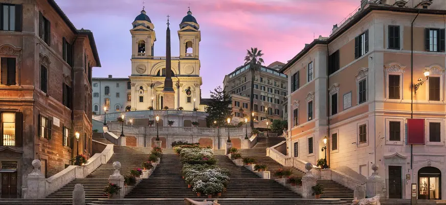 Escalinata de la Plaza de España y la iglesia Trinità dei Monti al ocaso en Roma.