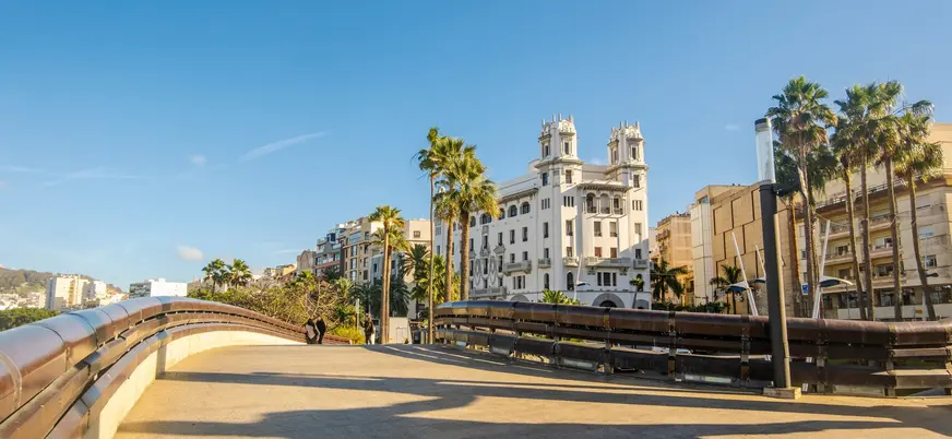 Puente urbano con palmeras y edificio histórico en el centro de Ceuta
