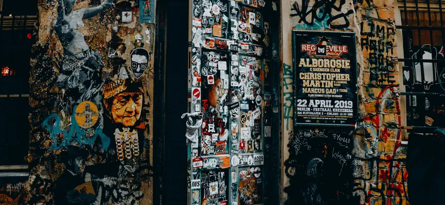 Puerta y paredes repletas de grafitis y pegatinas en Dead Chicken Alley, Berlín
