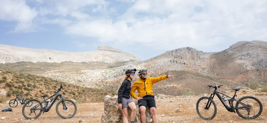 Pareja de ciclistas con e-bikes descansando en un mirador de El Chorro, Málaga