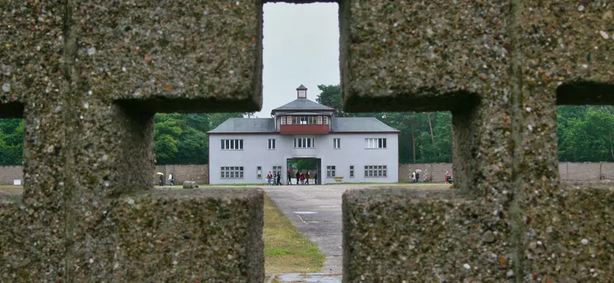 Torre A encuadrada a través de un hueco en el muro del Memorial de Sachsenhausen
