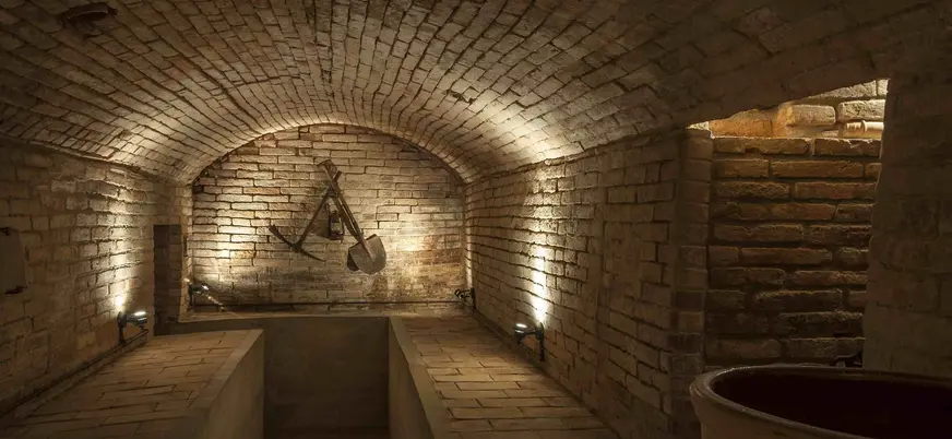 Sótano de ladrillo con herramientas antiguas en la Casa Museo Cal Gerrer