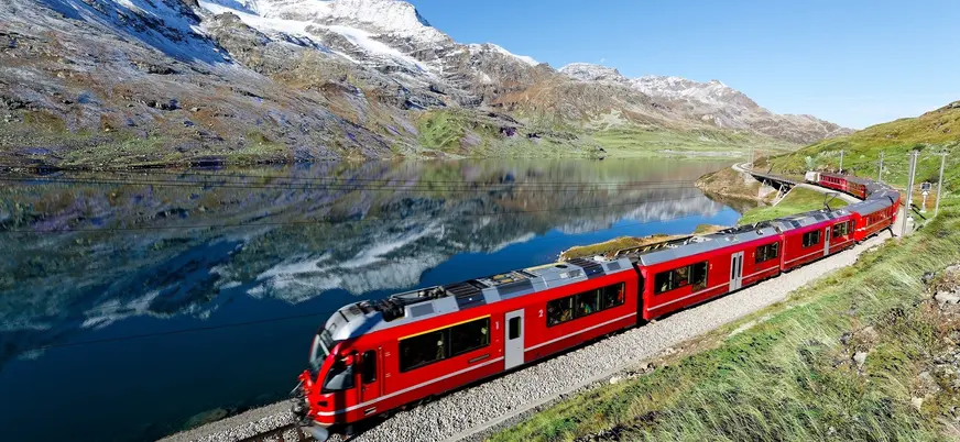 Bernina Express recorriendo los Alpes Suizos junto al lago en la ruta alpina