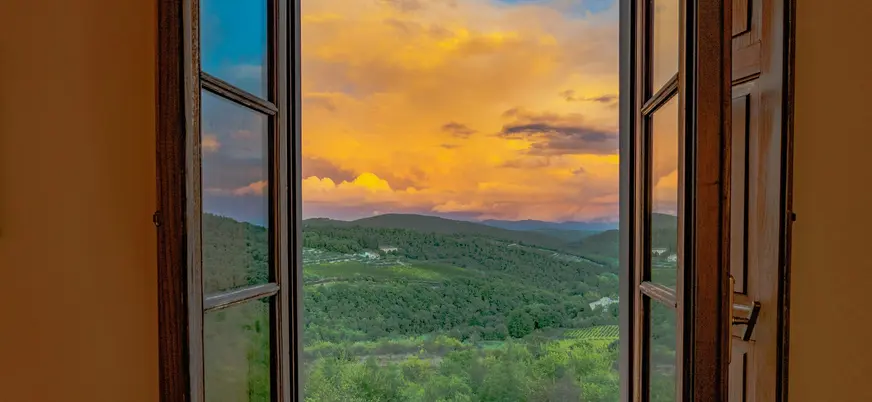 Atardecer sobre las colinas de la Toscana visto desde una ventana
