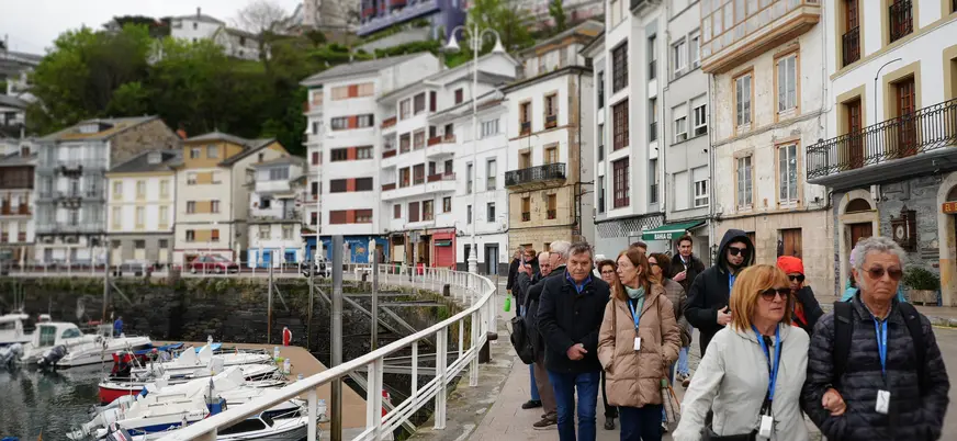 Grupo de excursionistas buendía paseando por el puerto deportivo de Cudillero, Asturias