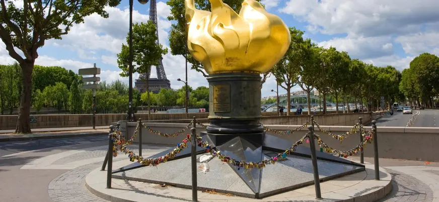 Llama de la Libertad con candados y la Torre Eiffel al fondo en París