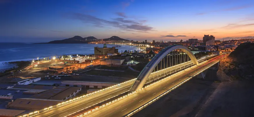 Puente de El Rincón iluminado al anochecer frente a la costa de Las Palmas.