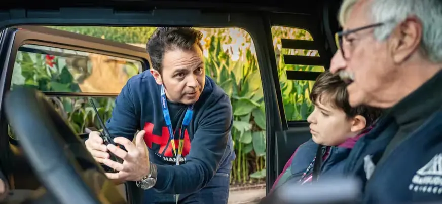 Guía turístico explicando el uso del walkie-talkie tour vehículo eléctrico cuevas del tesoro, málaga, españa