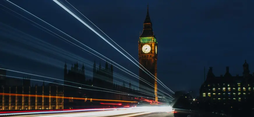 Big Ben iluminado de noche con estelas de luz de vehículos en movimiento