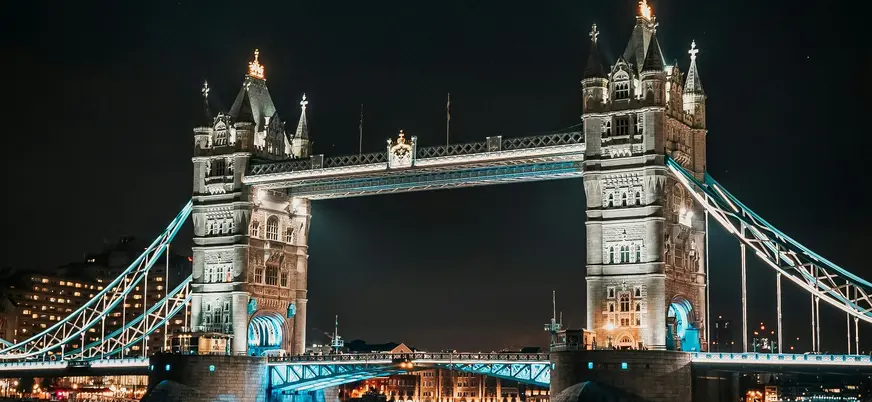 Puente de la Torre de Londres iluminado de noche sobre el río Támesis.