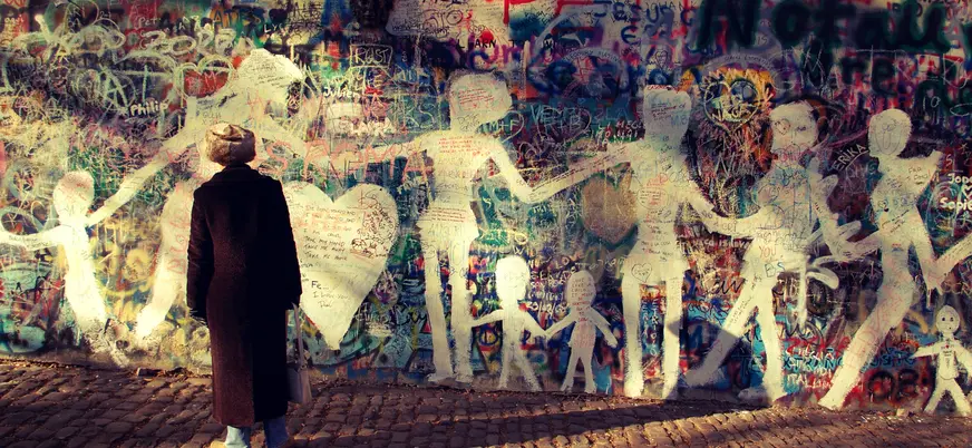 Persona admirando el icónico Muro de John Lennon en Praga.