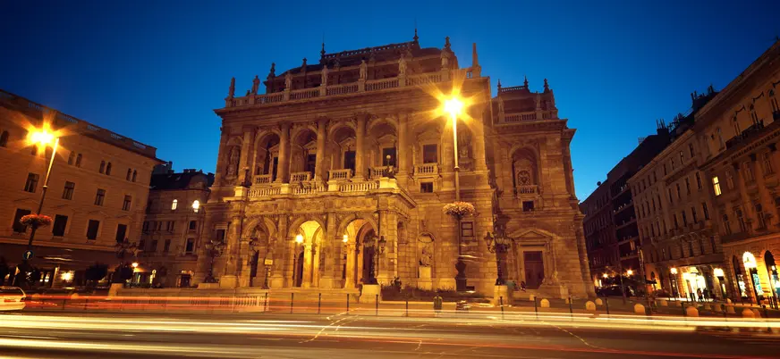 La iluminada Ópera Estatal de Hungría en Budapest de noche, con estelas de luz.