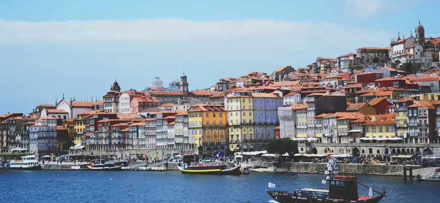 Fachadas de colores de Oporto frente al río Duero con barcos turísticos.