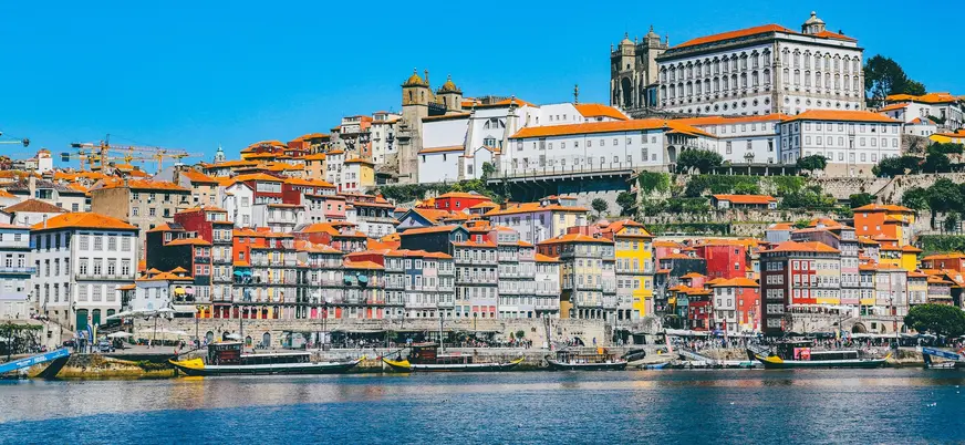 Fachadas de colores de Oporto frente al río Duero con barcos turísticos.