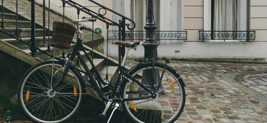 Bicicleta clásica apoyada en una escalera de piedra en Montmartre, París