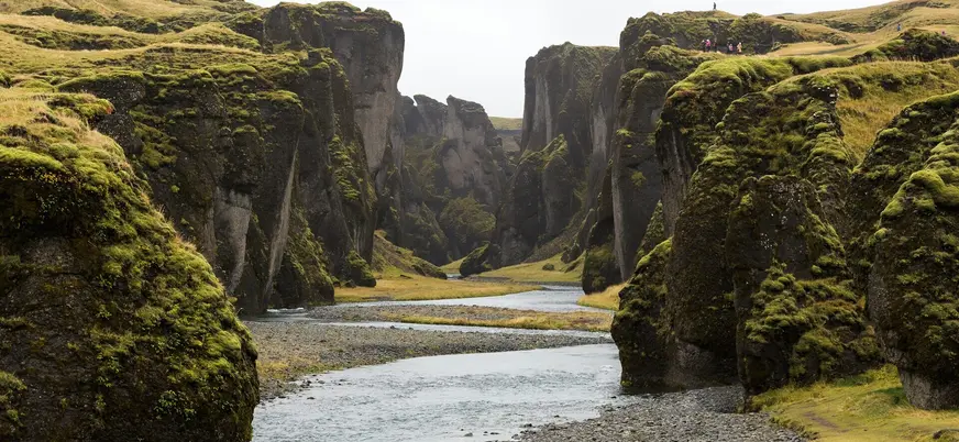 Cañón Fjaðrárgljúfur en el Parque Nacional Vatnajökull, Islandia, con paredes cubiertas de musgo y río serpenteante.