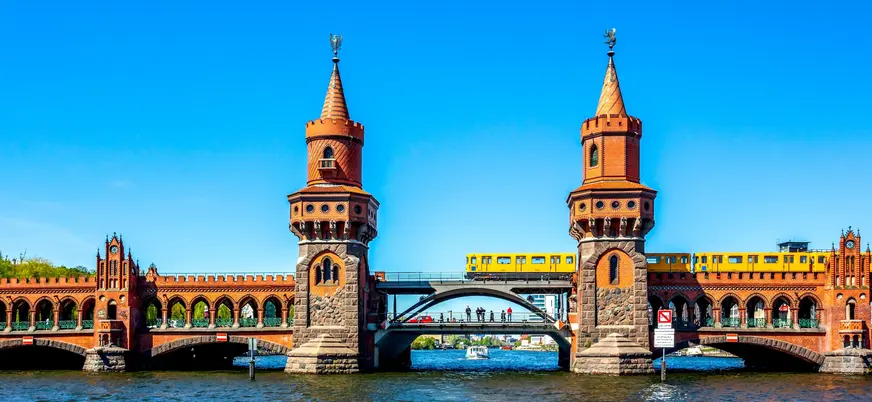 Tren amarillo cruzando el histórico puente de Oberbaum sobre el río Spree, Berlín
