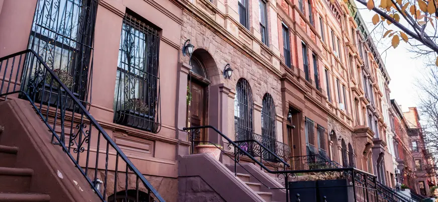 Casas brownstone con escaleras en barrio residencial de Nueva York, Estados Unidos