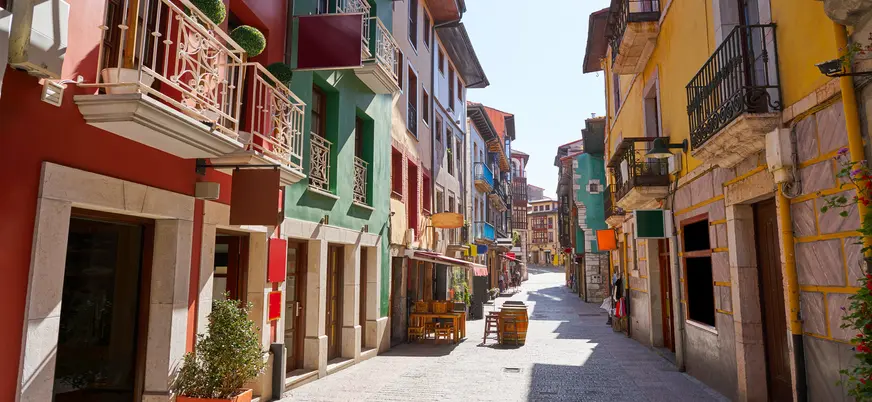 Calle estrecha de Ribadesella con fachadas de colores y balcones tradicionales